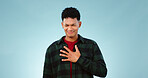 Man, hands or chest pain in studio for heart attack, 
emergency or cardiovascular problem. Young person, face and anxiety for asthma breathing, tuberculosis and pulmonary embolism by blue background
