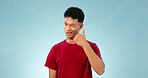 Portrait, man and wink to call me in studio on blue background in communication mockup. Cape Town, male model and flirting with hand emoji for connection, cellular or network with contact in space