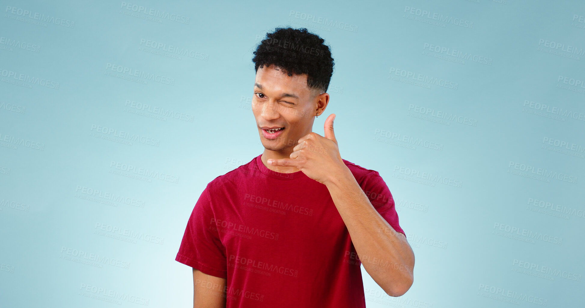 Buy stock photo Portrait, man and wink to call me in studio on blue background in communication mockup. Cape Town, male model and flirting with hand emoji for connection, cellular or network with contact in space