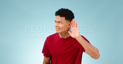 Buy stock photo Portrait, overhearing and hand gesture for eavesdropping with a man listening in studio on a blue background. Emoji, communication and secret with a confused young person in doubt about news