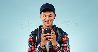 Buy stock photo Hiking, smile and typing with man, smartphone and internet on a blue studio background. Person, hiker and model with a cellphone, mobile user and contact with email, mockup space and website info