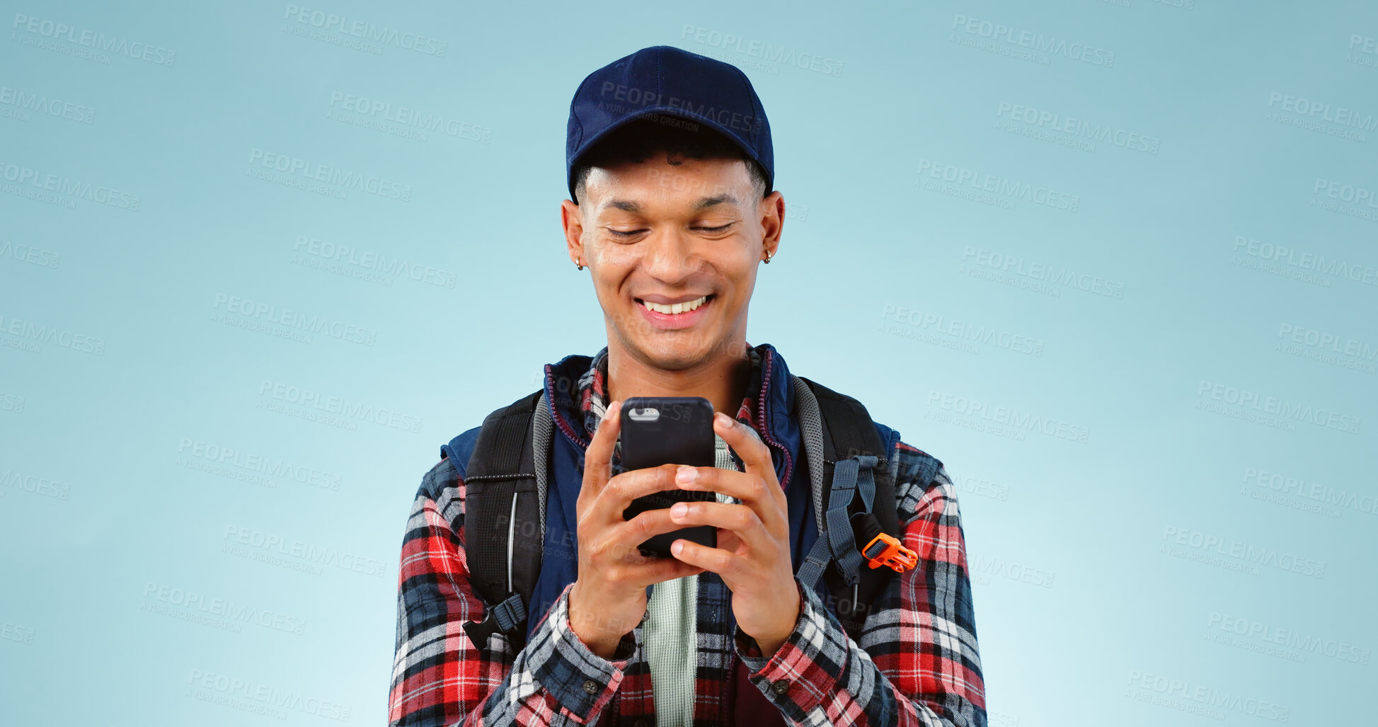 Buy stock photo Hiking, smile and typing with man, smartphone and internet on a blue studio background. Person, hiker and model with a cellphone, mobile user and contact with email, mockup space and website info