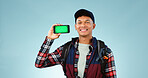 Hiking, green screen and man with a smartphone, portrait and happiness on a blue studio background. Person, hiker and model with mockup space, digital app and cellphone with tracking markers and face