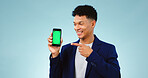 Business man, phone green screen and presentation for stock market, trading software or registration in studio. Young trader pointing to mobile app or website mockup isolated on a blue background