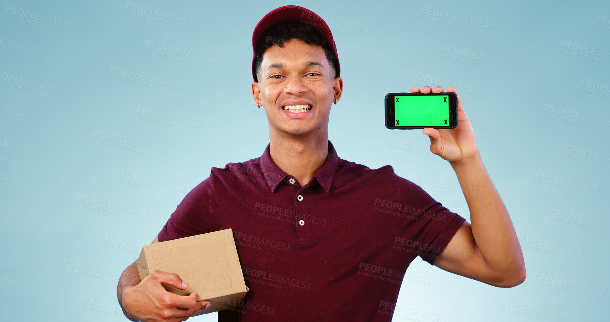 Buy stock photo Courier man, phone and green screen in studio for smile, mockup space or box by blue background. Supply chain expert, cardboard package and smartphone for app promotion, chromakey or tracking markers