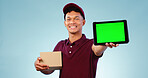 Delivery person, tablet and green screen in studio for smile, mockup space and box by blue background. Courier man, cardboard package and portrait for app promotion, chromakey and tracking markers