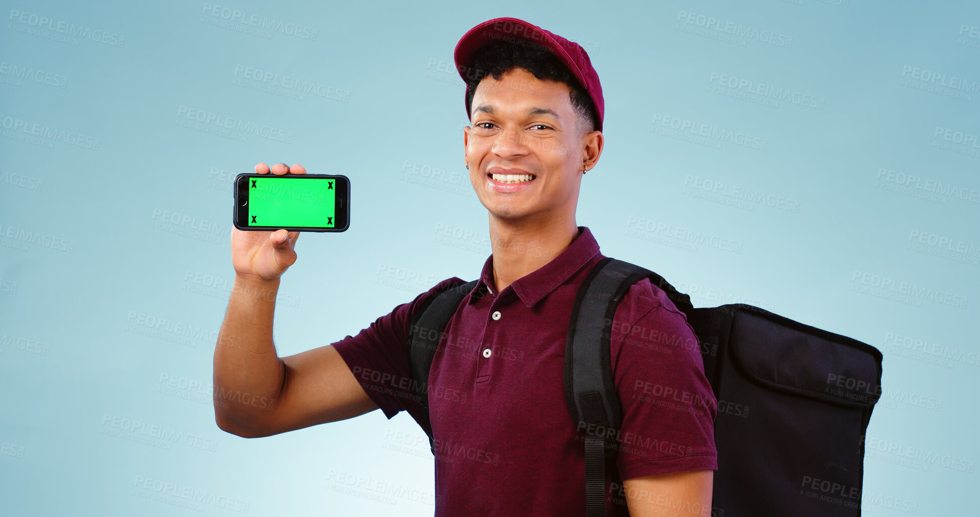 Buy stock photo Delivery man, phone and green screen in studio with smile, mockup space and bag by blue background. Supply chain portrait, backpack and smartphone for app promotion, ecommerce and tracking markers