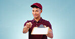 Courier man, clipboard and signature in studio portrait, smile and service with pen by blue background. African delivery guy, paperwork and document for commerce, logistics or writing in shipping job