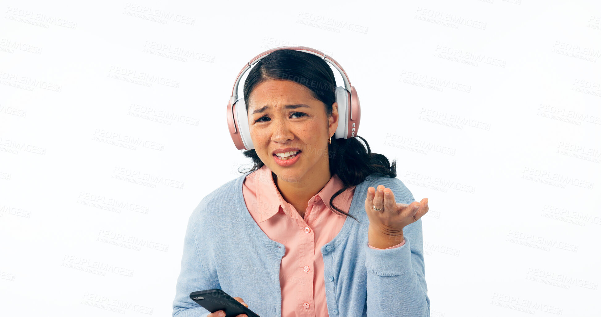 Buy stock photo Woman, confused and smartphone in portrait in headphones, music and streaming in question in studio mockup. Young person, asian and doubt on face, audio playlist and online radio by white background