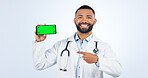 Phone, green screen and portrait of doctor pointing to registration, sign up or info in white background. Studio, healthcare and mobile app for telehealth services, communication or presentation
