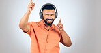 Happy man, headphones and dancing or listening to music for audio streaming against a studio background. Male person enjoying sound track, podcast or radio with headset for rhythm on mockup space
