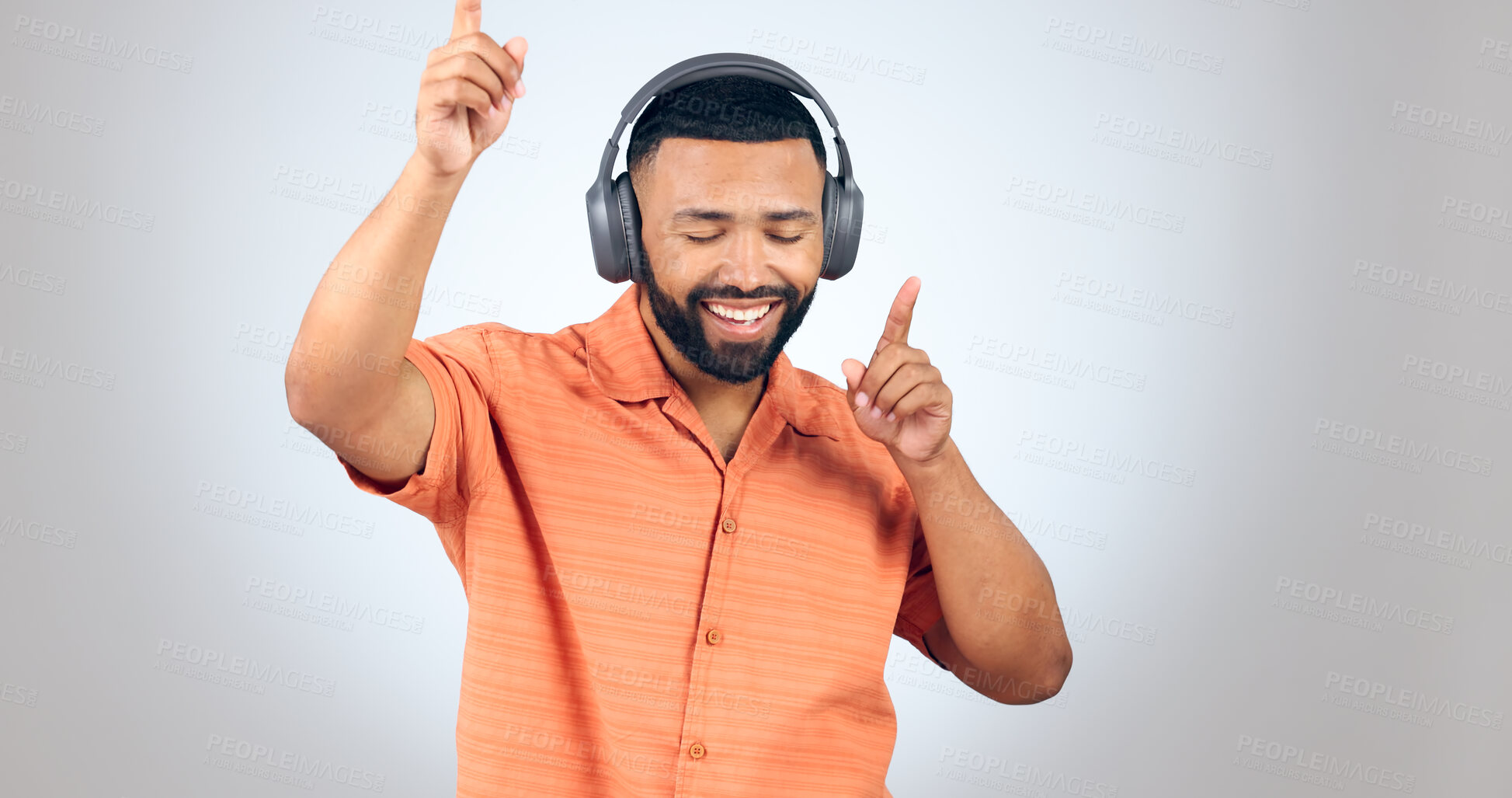 Buy stock photo Happy man, headphones and dancing or listening to music for audio streaming against studio grey background. Male person enjoying sound track, podcast or radio with headset for rhythm on mockup space