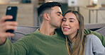 Couple, sofa and selfie with kiss in home living room with love, care and bonding together for post on web blog. Man, woman and hug with photography, memory and profile picture on social network app
