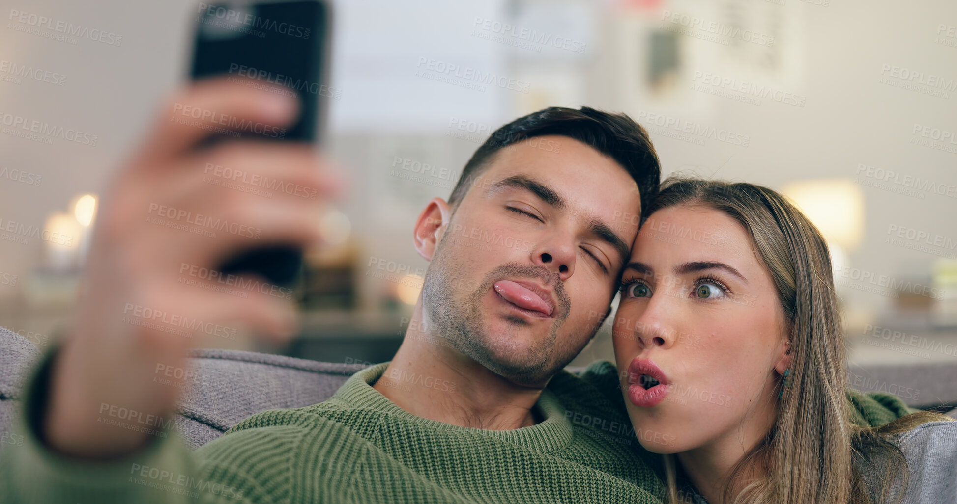 Buy stock photo Couple, sofa and selfie with funny face in home living room with cross eyes, tongue and together for web blog. Man, woman and comic memory with photography for profile picture on social network app