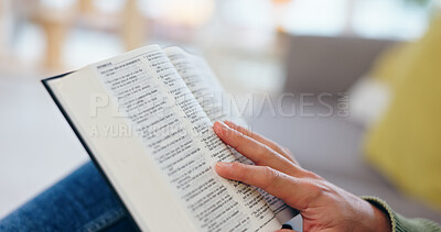 Buy stock photo Hand, bible study and closeup for reading in home for faith, knowledge or spiritual information on sofa. Person, zoom and book for hope, worship or connection to God in living room for peace in house