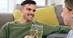 Couple, happy man and champagne for cheers in living room for celebration, anniversary or event. Husband, face and excited emoji with wife for good news with drink, glass and home by sitting on floor