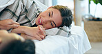 Holding hands, smile and young couple in bed together to relax or wake up in the morning of a weekend. Face, romance or happy with a young man and woman closeup in the bedroom of their home for love