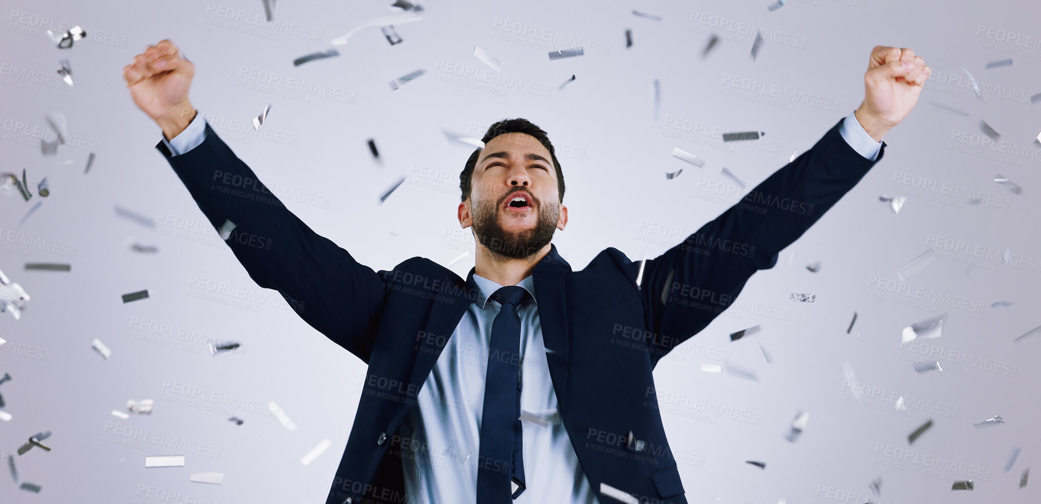 Buy stock photo Happy businessman, fist pump and confetti in celebration, winning or achievement against a gray studio background. Excited man employee in party prize, good news or business promotion for success