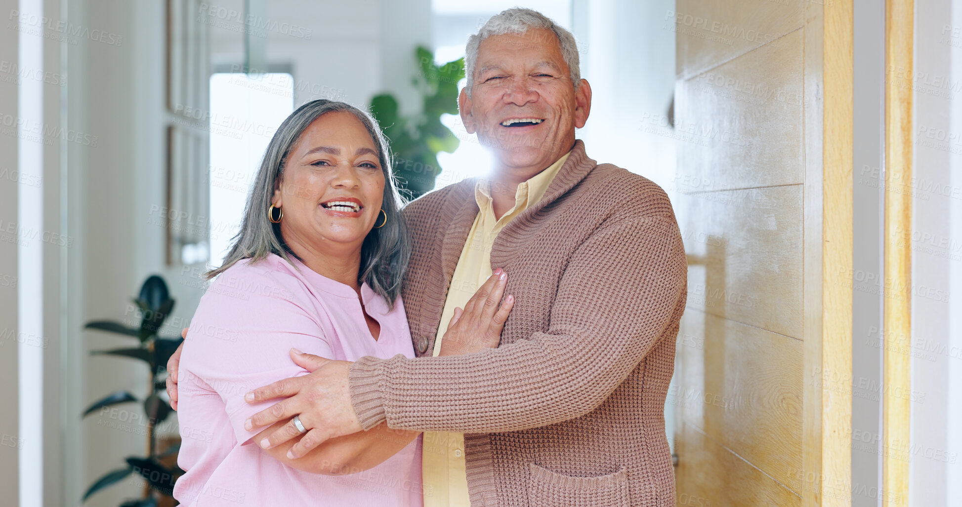 Buy stock photo Portrait, love and smile with a senior couple in their retirement home together for friendly welcome. Happy, hug or embrace with an elderly man and woman in the doorway entrance to their apartment