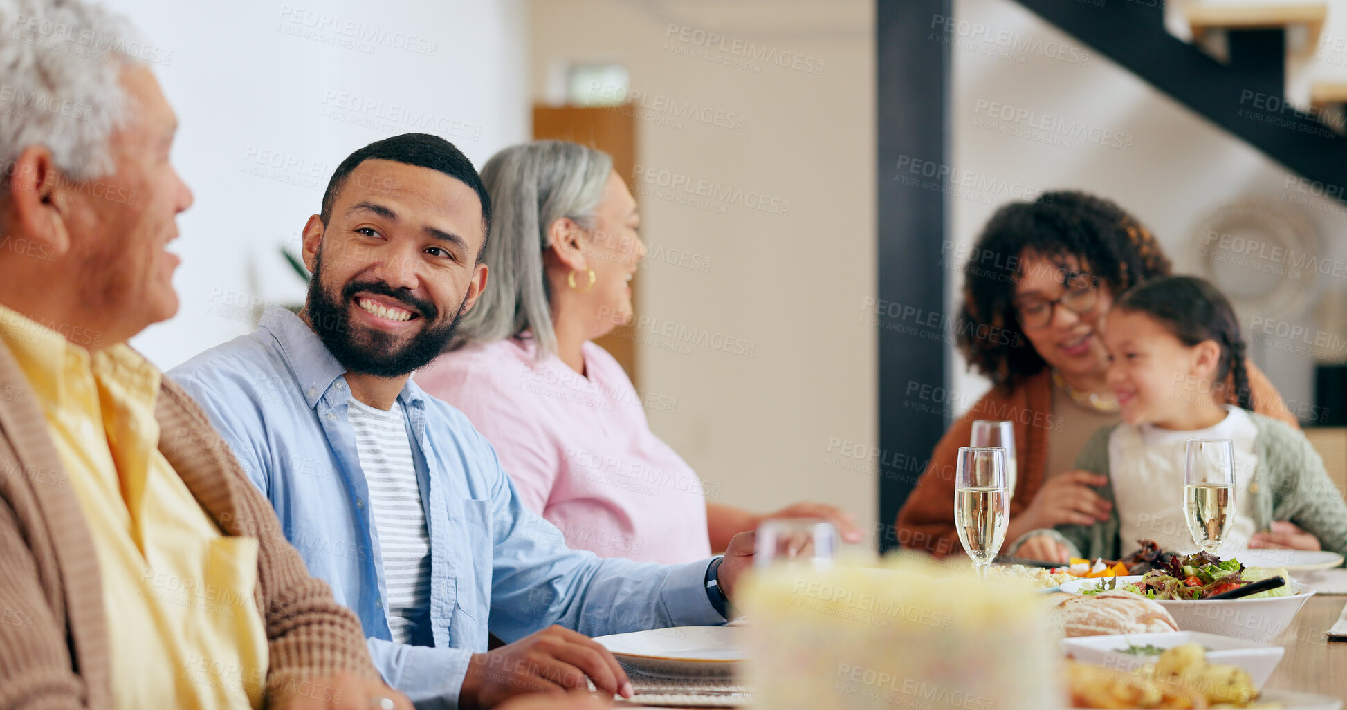 Buy stock photo Family, food and feast the dinner table with a man taking to his senior father while eating a meal together. Smile, conversation and festive celebration with a group of people chatting in a home