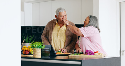 Buy stock photo Senior couple, cooking and taste in a kitchen with tablet for recipe, research or online tutorial at home. Love, food and old people with digital app for nutrition, blog or vegetables for meal prep