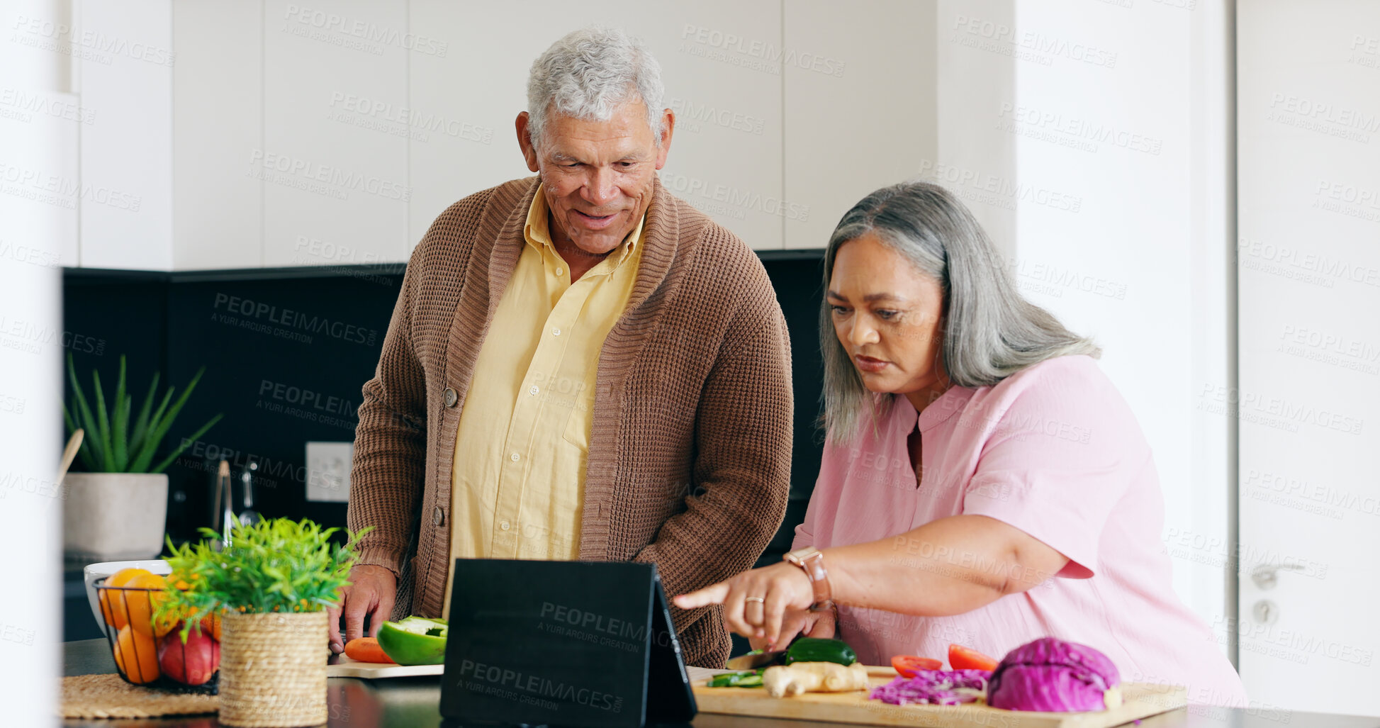 Buy stock photo Senior, couple and cooking in kitchen with tablet for dinner, lunch or vegetables with support, help and love. Elderly, man and woman with watching, peace and nutrition for bonding or relationship