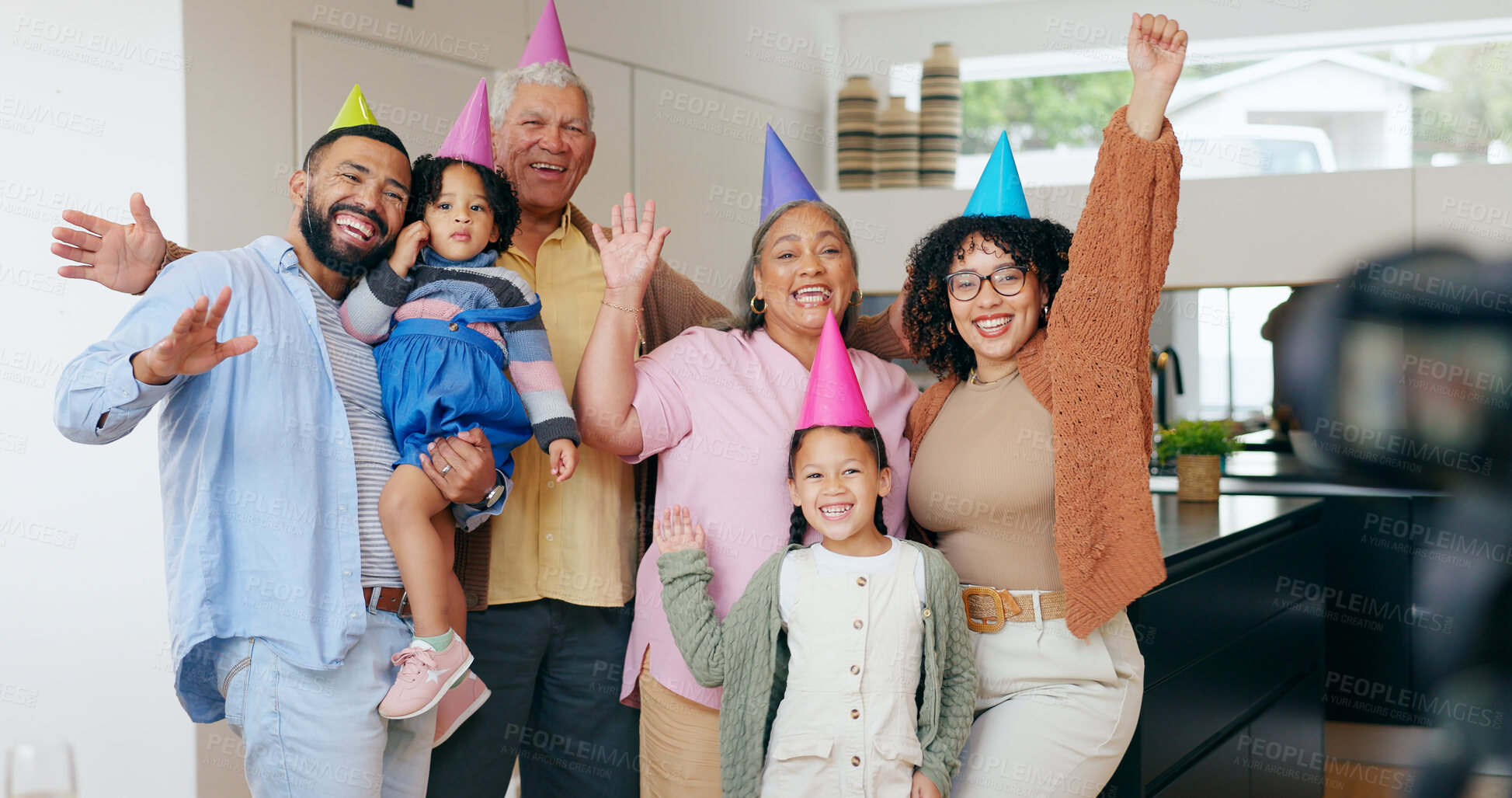 Buy stock photo Happy family, birthday hats and photography for party, children and parents. House, grandparents and celebration with timer, excited and cheers with hands, wow and bonding together for memories