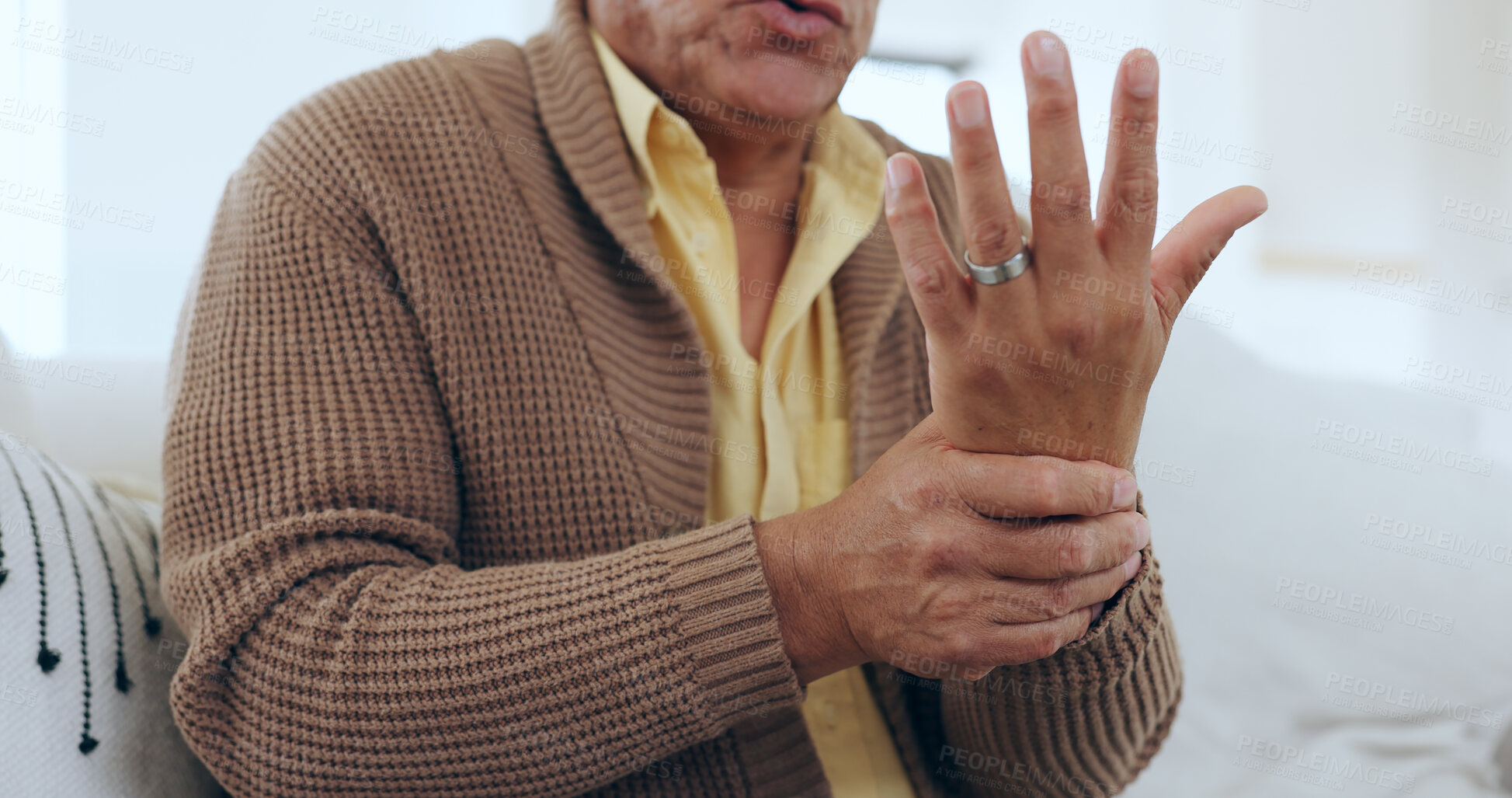 Buy stock photo Hand, wrist pain and injury with an elderly person on a sofa in the living room of a home to massage a joint. Medical, anatomy or ache and a senior in his apartment with arthritis or carpal tunnel