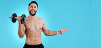 Gym, portrait and happy man with dumbbell or hand pointing to studio for fitness, promo or info on blue background. Face, smile and male bodybuilder show sign up, presentation or membership offer