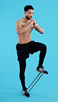 Serious man, legs and resistance band in fitness, workout or training against a blue studio background. Male person, athlete or model with straps for cardio exercise, endurance or stamina on mockup