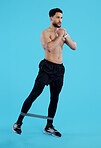 Serious man, legs and resistance band in workout, training or fitness against a blue studio background. Male person, athlete or model with straps for cardio exercise, endurance or stamina on mockup