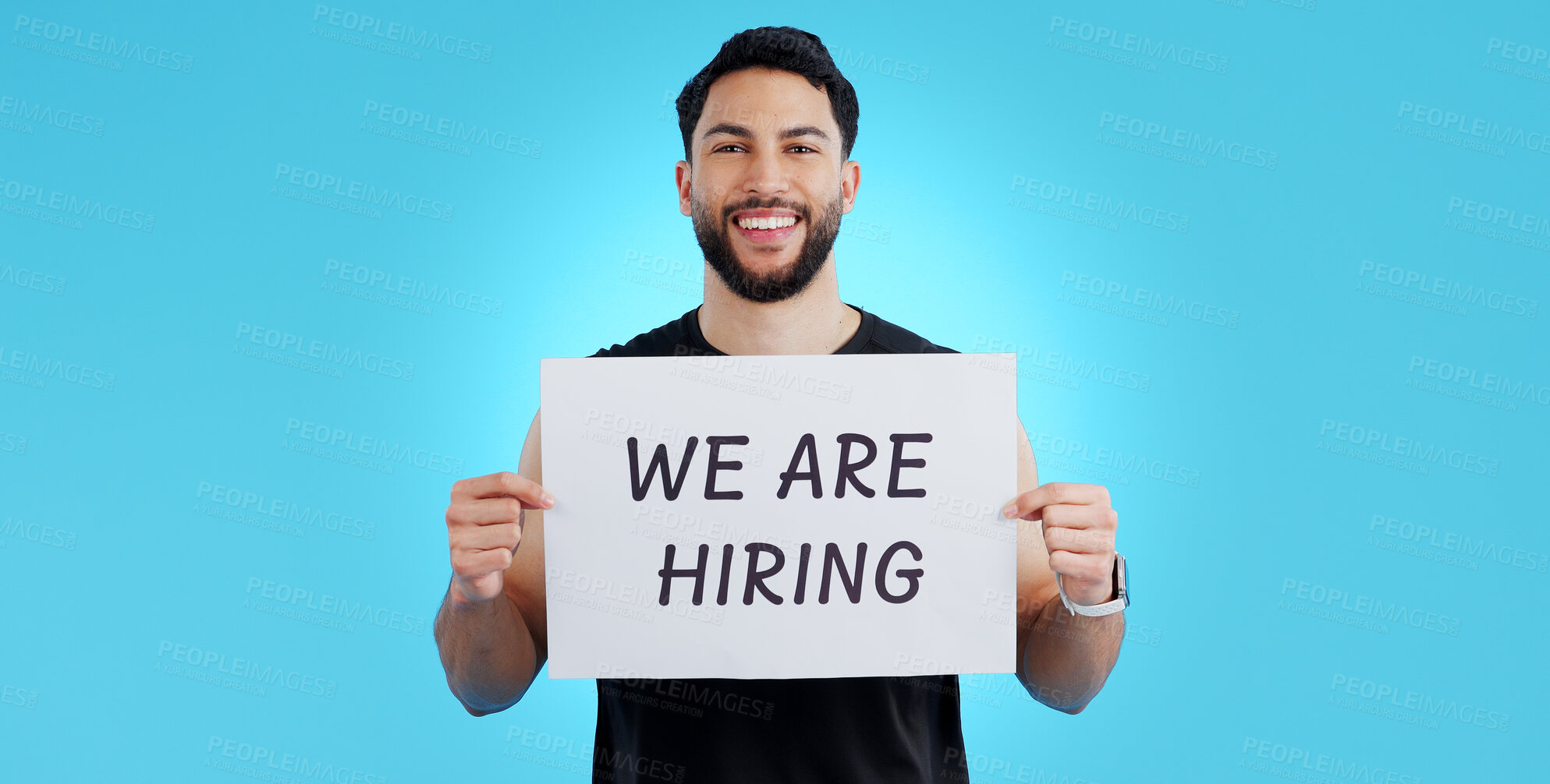 Buy stock photo Portrait, smile and man with we are hiring, poster or announcement in studio on blue background. Recruitment, banner and face of male model with news, announcement or business, opportunity or offer