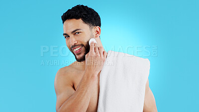 Buy stock photo Skincare, portrait and happy man with cotton pad in studio for luxury, grooming or wellness on blue background. Face, smile and model with facial swab for cleaning, cosmetics or after shower beauty