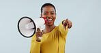 Happy black woman, portrait and pointing to you with megaphone for choice against a gray studio background. African female person smile with loudspeaker or bullhorn for selection, choosing or sale