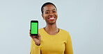 Happy black woman, portrait and phone green screen for advertising against a gray studio background. Face of African female person smile showing mobile smartphone display, marketing or app on mockup