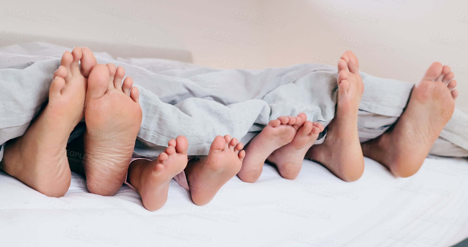 Buy stock photo Family, feet and sleeping in bed, morning or relax together with kids and parents under blanket. Foot, closeup or children rest with mom and dad in bedroom with comfort in home on vacation or holiday