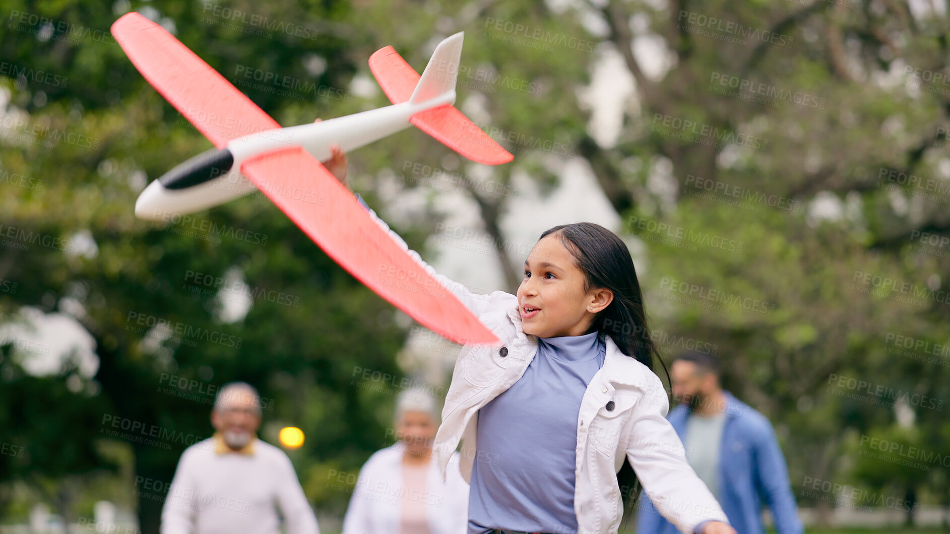 Buy stock photo Outdoor, family and girl with an airplane, playing and child in park with parents for holiday, adventure and weekend outdoors with joy. Happy, group or kid with plane, mom or dad in nature with a toy