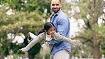 Outdoor, father and girl with love, airplane and weekend break in a park, happiness and bonding together. Family, dad and kid outside, game and forest with fresh air, cheerful and smile with freedom