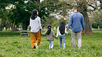 Family, holding hands and walking in park from the back with love and care together in nature. Travel, insurance and parents with children to support on adventure, journey or holiday in countryside