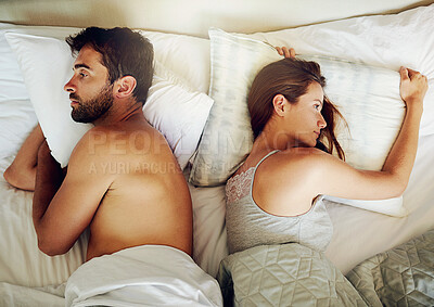 Buy stock photo High angle shot of an arguing couple with their backs turned on each other in bed