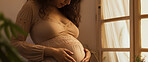 Pregnant, woman and mother touching or caressing her belly while relaxing at home. Expecting, mom to be and cropped of a female rubbing her stomach and preparing for motherhood and childbirth