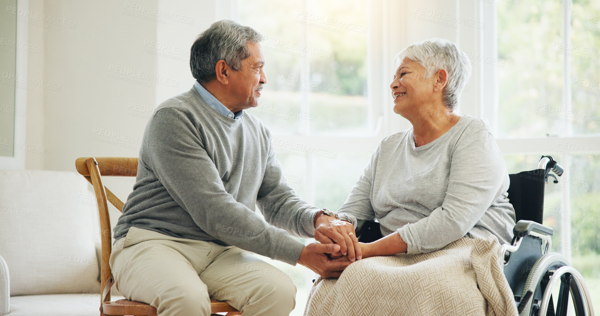 Buy stock photo Love, retirement and an old woman in a wheelchair with her husband in the living room of their home together. Trust, support and an elderly man talking to his wife with a disability in the apartment