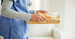Woman, hands and nurse with breakfast tray in elderly care, support or volunteer at home. Closeup of female person, medical doctor or caregiver holding snack, meal or service for healthy nutrition