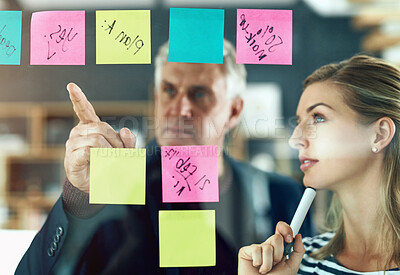 Buy stock photo Shot of two colleagues having a brainstorming session in a modern office