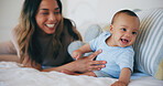 Family, love and a woman on the bed with her baby in their home together for care or bonding. Children, smile and a happy young mother in the bedroom of an apartment with her adorable infant son