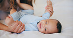 Hands, love and baby in bed with mother at home, play and bonding together, support or family trust. Child, mom and closeup of infant in bedroom, smile and security, care of toddler and growth of kid