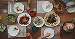 Family home, top view and thanksgiving food on table with hands, plate and dish for festive celebration. Vegetables, bread and chicken in dining room, house and people together for holiday brunch