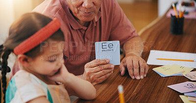 Buy stock photo Child, senior man and education or card, teaching and learning at home, language and support. Girl, grandfather and letters or tutoring, assessment and alphabet for development or english homework