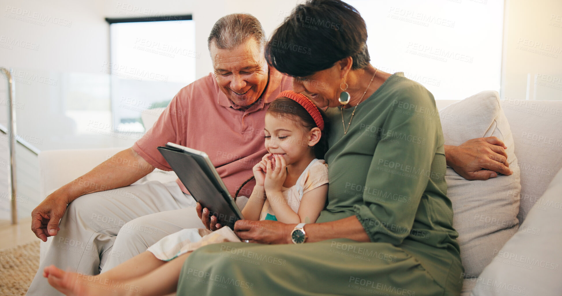 Buy stock photo Tablet, elearning and child with grandparents on sofa in the living room of modern family house. Happy, online school and girl on digital technology relaxing with senior people in retirement at home.