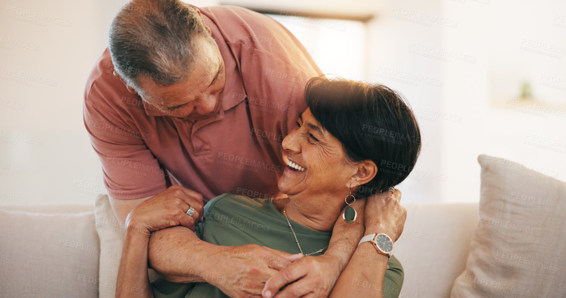 Buy stock photo Mature, man and woman with smile for embrace in living room on sofa for love, care or romance in relationship. Happy couple, together or married in laugh by funny joke, memory or conversation in home